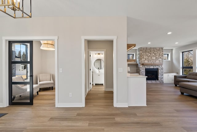 18436 56th Ct N, Plymouth, MN 55446 - living room with light wood finished floors, baseboards, recessed lighting, a stone fireplace, and a chandelier