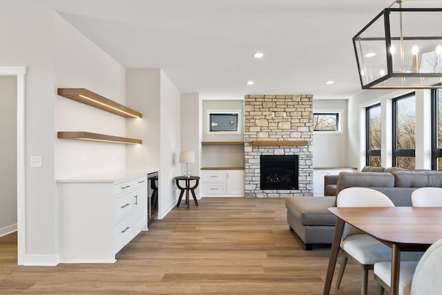 18436 56th Ct N, Plymouth, MN 55446 - living room with light wood-type flooring, beverage cooler, recessed lighting, a stone fireplace, and baseboards