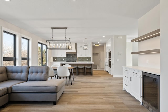 18436 56th Ct N, Plymouth, MN 55446 - living area featuring wine cooler, light wood finished floors, recessed lighting, a chandelier, and a bar