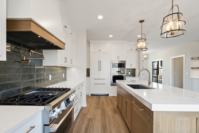 18436 56th Ct N, Plymouth, MN 55446 - kitchen with stainless steel appliances, a sink, light countertops, backsplash, and light wood-type flooring