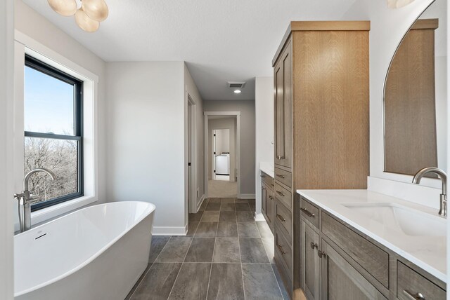 18436 56th Ct N, Plymouth, MN 55446 - full bath with vanity, a soaking tub, baseboards, and washer / clothes dryer