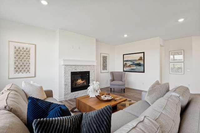 living room featuring light hardwood / wood-style flooring and a stone fireplace