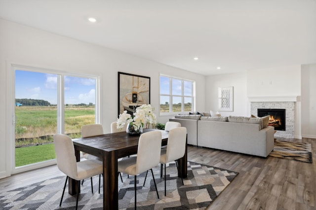 dining area with a wealth of natural light, hardwood / wood-style floors, and a fireplace