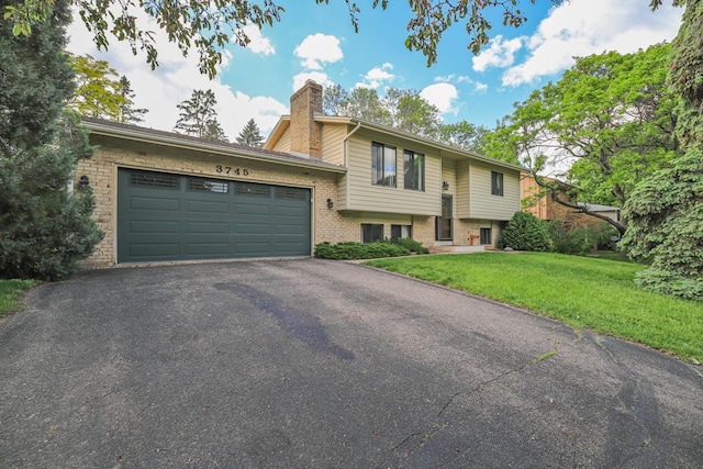 view of front of house with a garage and a front lawn