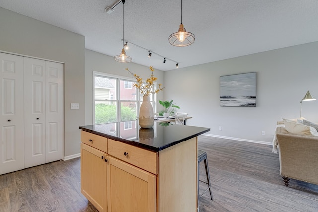 kitchen with dark hardwood / wood-style flooring, pendant lighting, a textured ceiling, and light brown cabinets