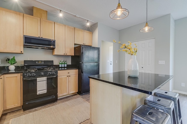 kitchen with black appliances, track lighting, a center island, light brown cabinetry, and hanging light fixtures