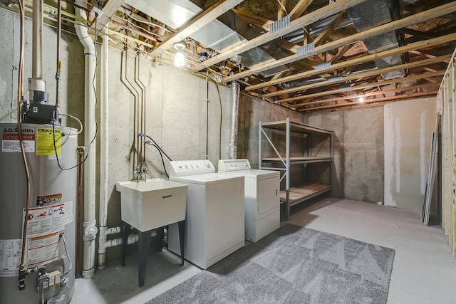 washroom featuring sink, gas water heater, and washing machine and clothes dryer