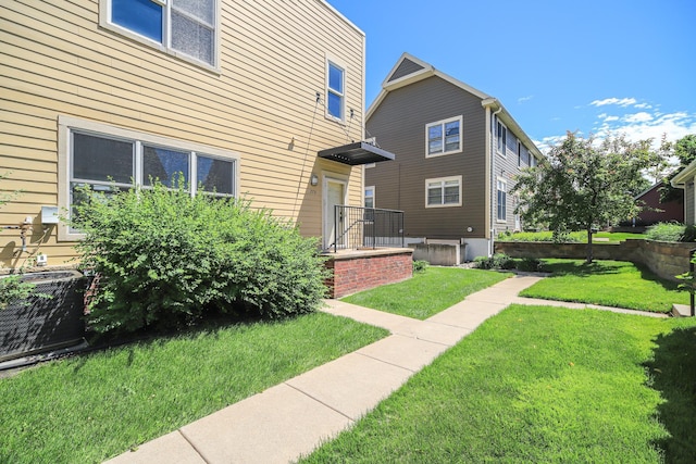 exterior space with central air condition unit and a yard