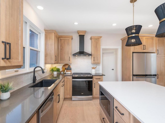 kitchen with sink, appliances with stainless steel finishes, tasteful backsplash, decorative light fixtures, and wall chimney exhaust hood