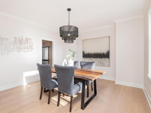 dining area with a notable chandelier, light hardwood / wood-style flooring, and ornamental molding