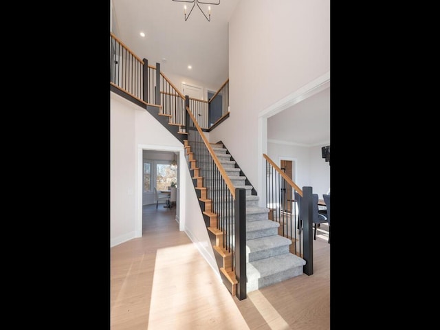 staircase featuring wood-type flooring and a notable chandelier