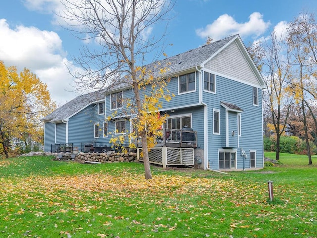 rear view of property featuring a yard and a deck