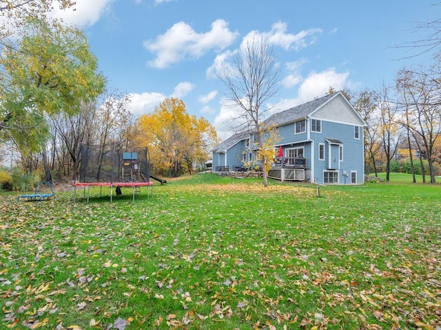 view of yard with a trampoline and a playground