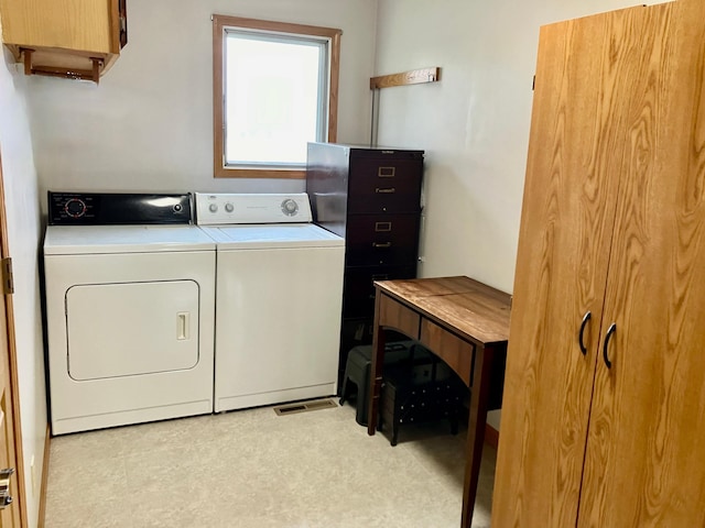 laundry room with cabinets and washing machine and clothes dryer