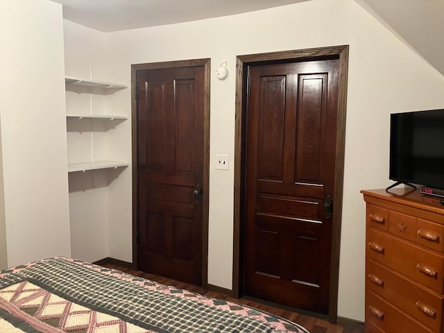 bedroom with vaulted ceiling and dark hardwood / wood-style floors