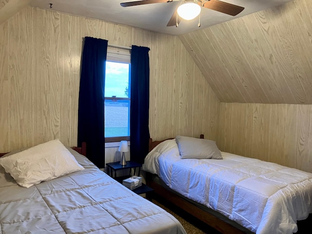 bedroom with lofted ceiling, wooden walls, ceiling fan, and a water view