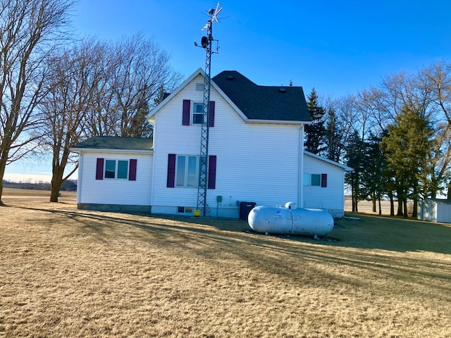 back of property featuring central AC unit and a yard