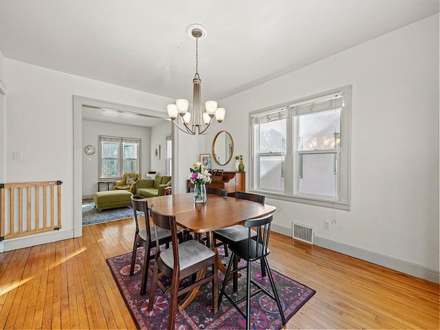 dining area with a notable chandelier and light wood-type flooring