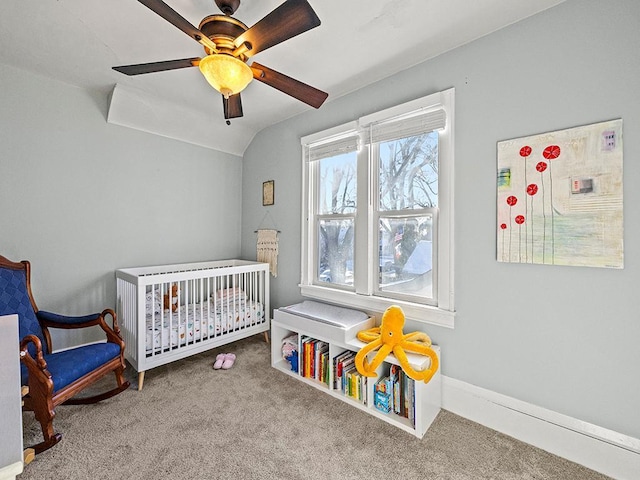 carpeted bedroom with lofted ceiling, a nursery area, and ceiling fan