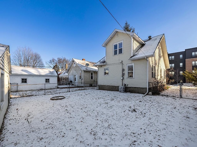 view of snow covered rear of property