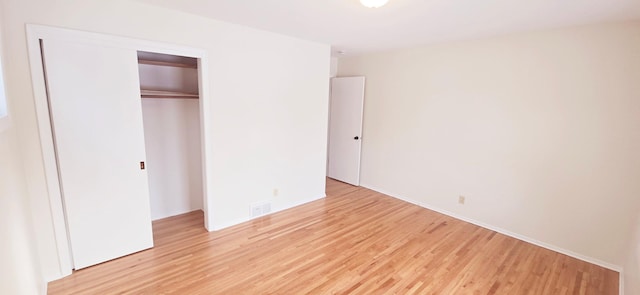 unfurnished bedroom with light hardwood / wood-style floors and a closet