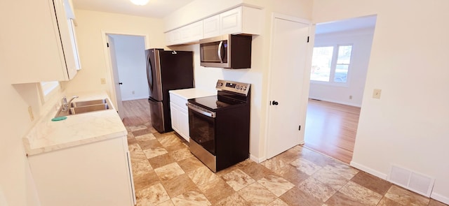 kitchen featuring sink, light stone countertops, white cabinets, and appliances with stainless steel finishes