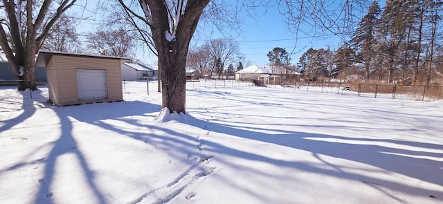 snowy yard featuring a storage unit