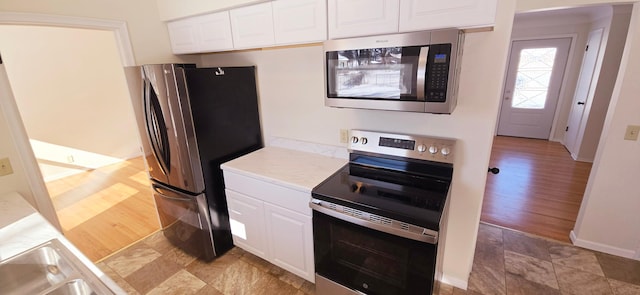 kitchen featuring white cabinetry, appliances with stainless steel finishes, and light hardwood / wood-style floors