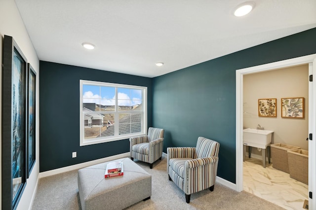 sitting room featuring light colored carpet