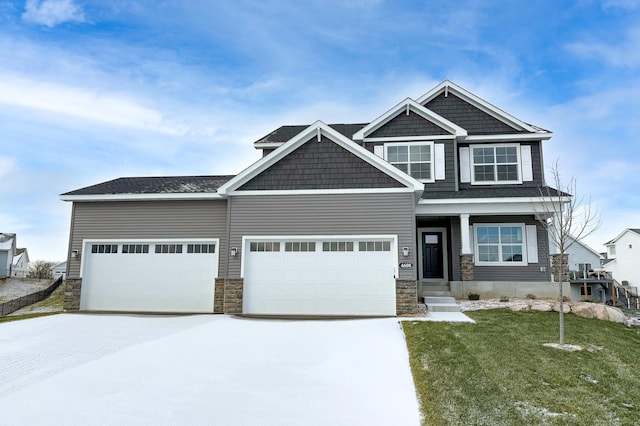 craftsman inspired home featuring a garage and a front lawn