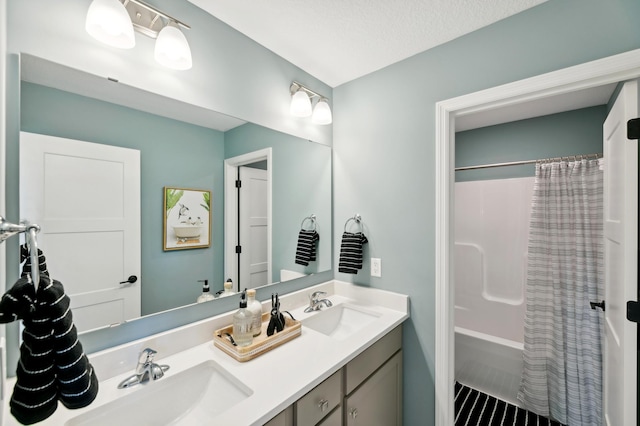 bathroom with vanity, shower / bath combination with curtain, and a textured ceiling