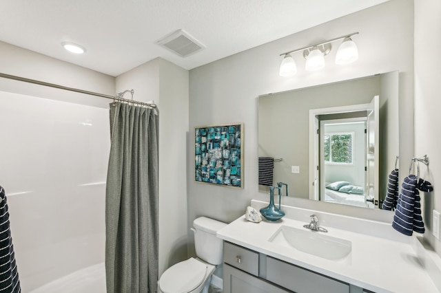 bathroom with vanity, curtained shower, and toilet