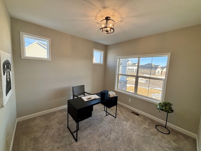 office space with an inviting chandelier, a textured ceiling, carpet, and a wealth of natural light