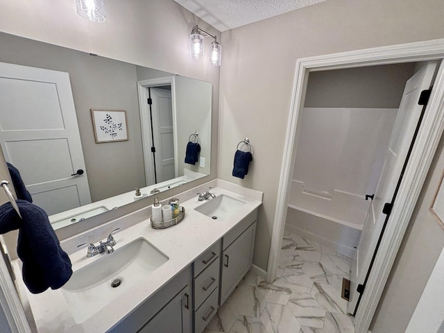 bathroom featuring shower / bath combination, vanity, and a textured ceiling