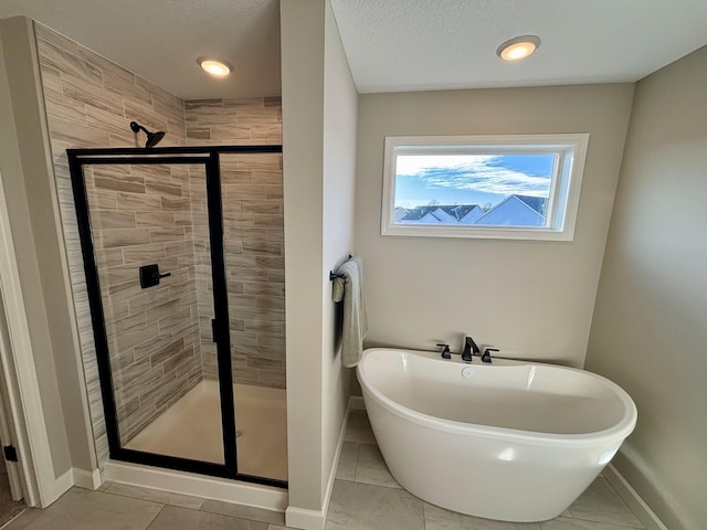 bathroom featuring tile patterned flooring, plus walk in shower, and a textured ceiling