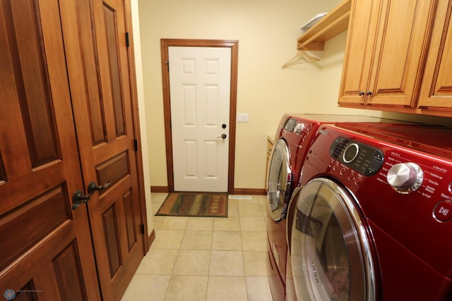 clothes washing area featuring washer and clothes dryer and cabinets