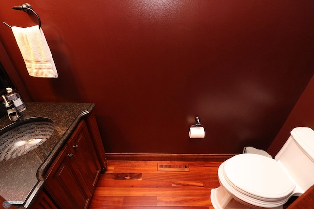 bathroom with vanity, toilet, and hardwood / wood-style floors