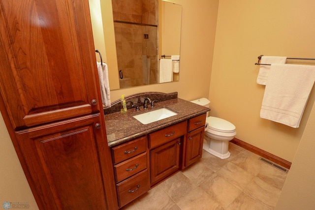 bathroom featuring vanity, a tile shower, and toilet