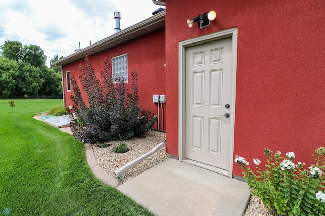 entrance to property with a lawn