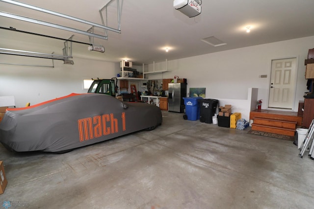 garage featuring a garage door opener and stainless steel fridge