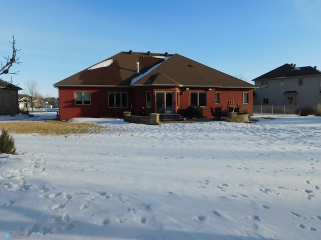 view of snow covered rear of property