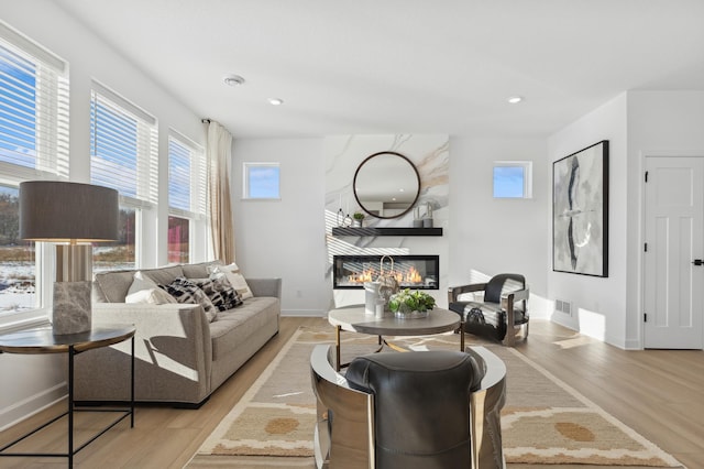 living room featuring a large fireplace and light wood-type flooring