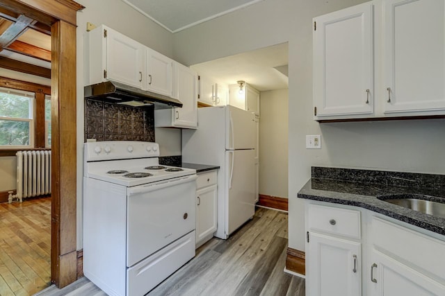 kitchen featuring radiator, white cabinetry, dark stone countertops, white appliances, and light hardwood / wood-style flooring