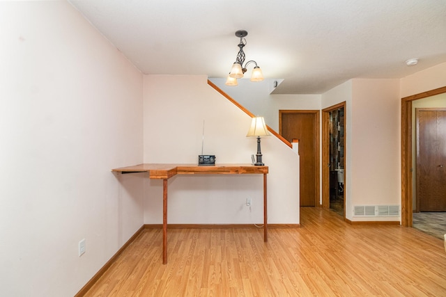 interior space with an inviting chandelier and light hardwood / wood-style flooring