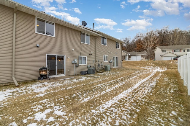 snow covered back of property with central AC