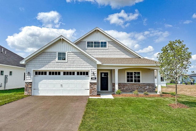 craftsman inspired home featuring a garage and a front lawn