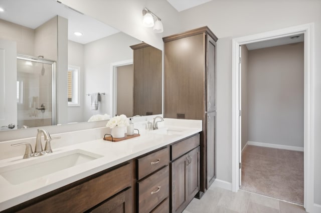 bathroom featuring a shower with door and vanity