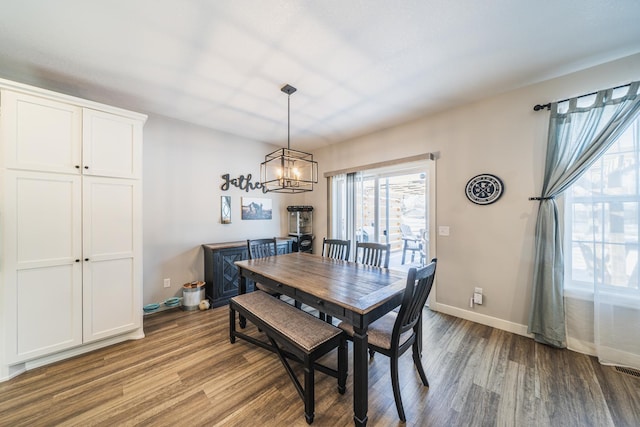 dining area with light hardwood / wood-style floors and a chandelier