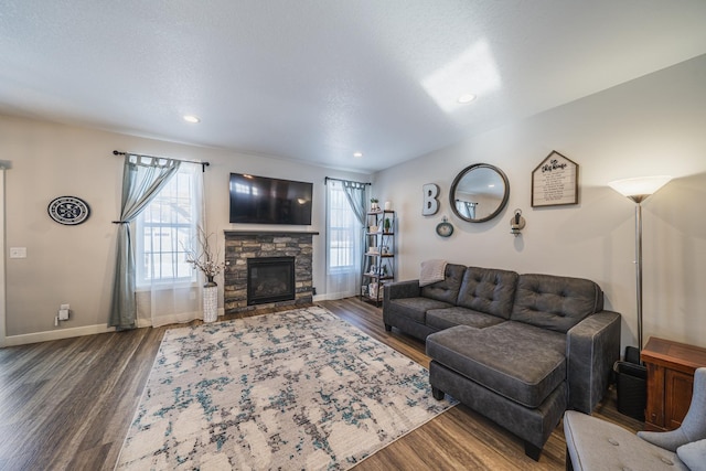 living room with a fireplace, dark wood-type flooring, and a textured ceiling