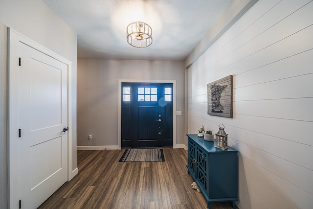 foyer entrance with dark hardwood / wood-style floors and a textured ceiling